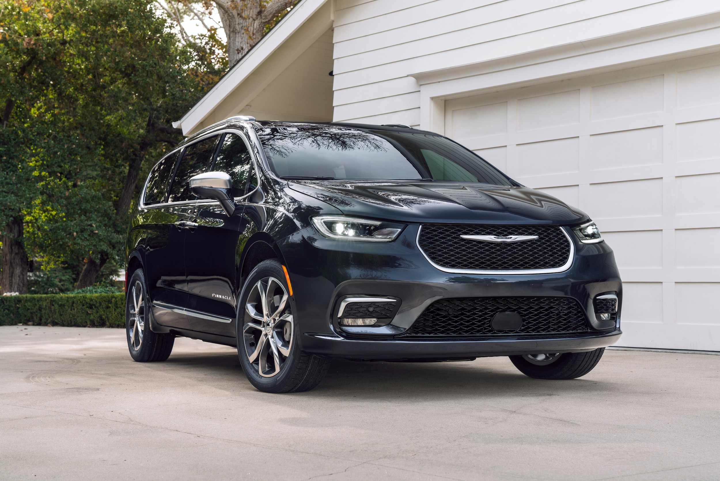 A black Chrysler Pacifica parked in a residential driveway